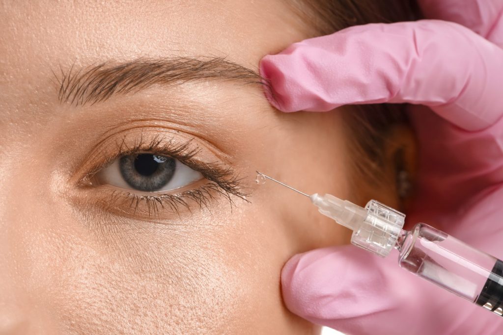 close up of womans face getting a botox injection around her eye area Botox in Fort Myers Florida at Skin Spot Laser Club treating forehead lines, crow’s feet, frown lines, and brow area for smoother more youthful looking skin