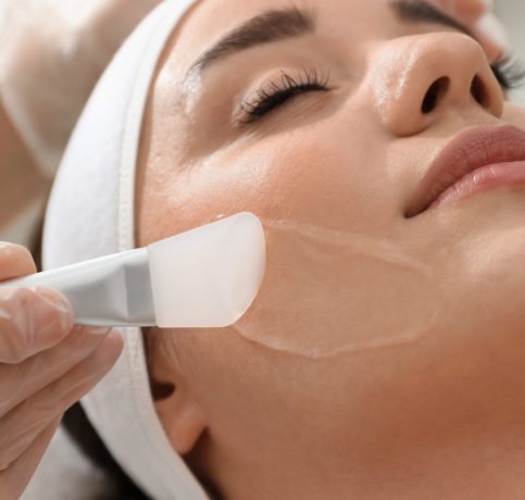Woman getting a facial with a peel being applied to her face
